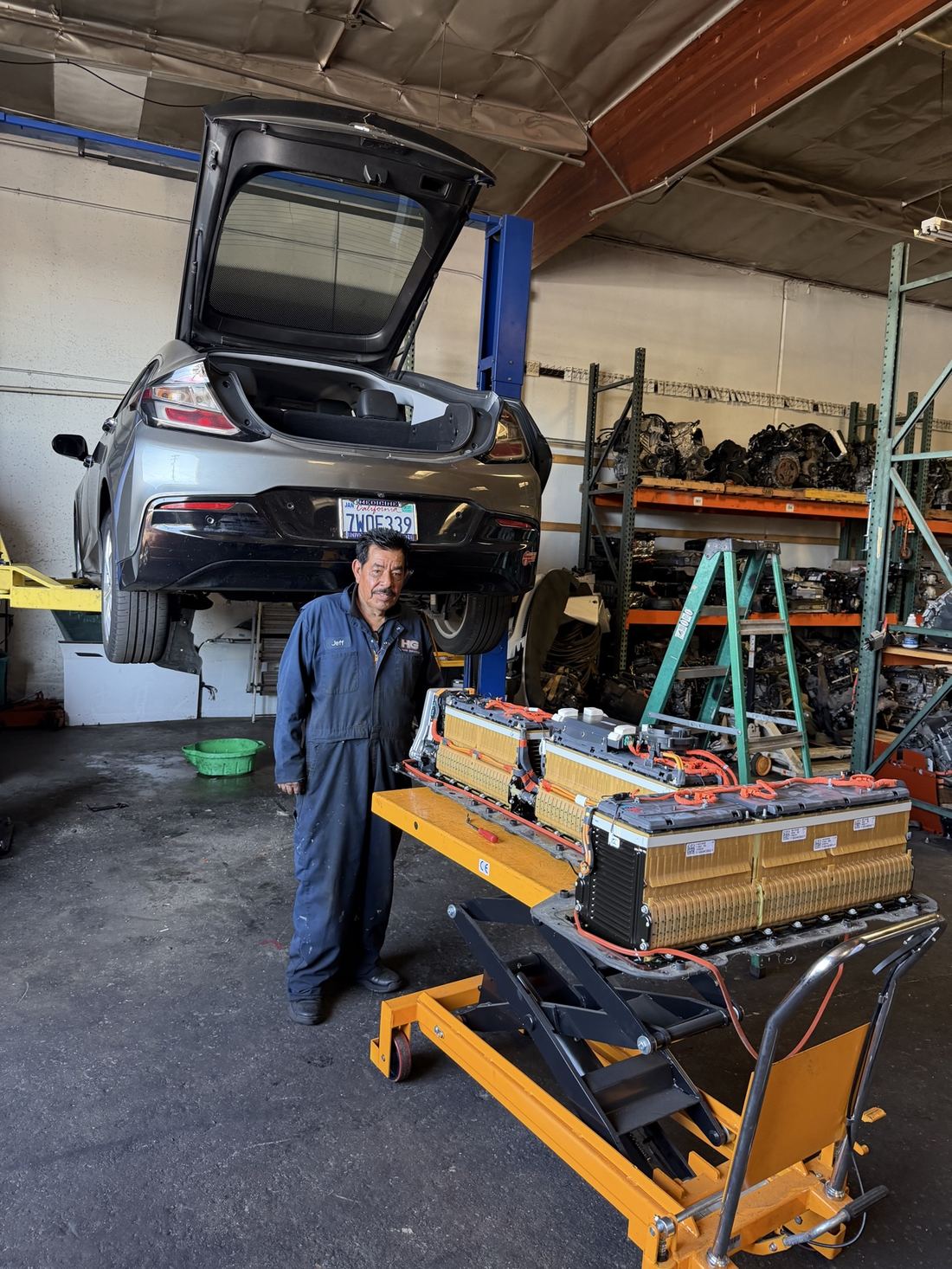 Technician with a hybrid battery pack on the lift table